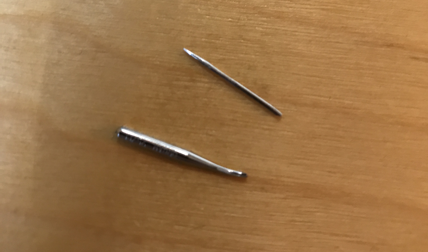image of a sewing machine needle broken in two pieces